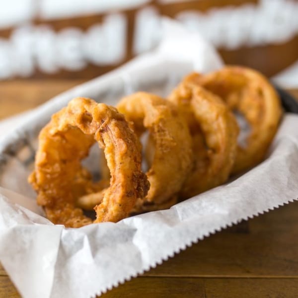 A basket of golden-brown, crispy onion rings from The Region restaurant.